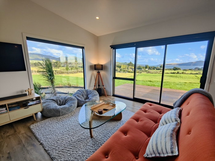 Photo of property: Take in the panoramic views from the cosy living room. There is WiFi and a smart TV with guest logins available for streaming services (Netflix, Neon, Prime Video, Sky Sport Now). Plenty of board games and reading material in the TV cabinet, too.