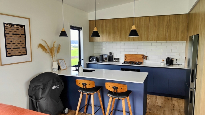 Photo of property: Full kitchen available with gas hob, oven, microwave, toaster, jug & Nespresso. There is also a Weber BBQ available for use.  Dine at the generously-sized breakfast bar, or alfresco at the picnic table on the deck.