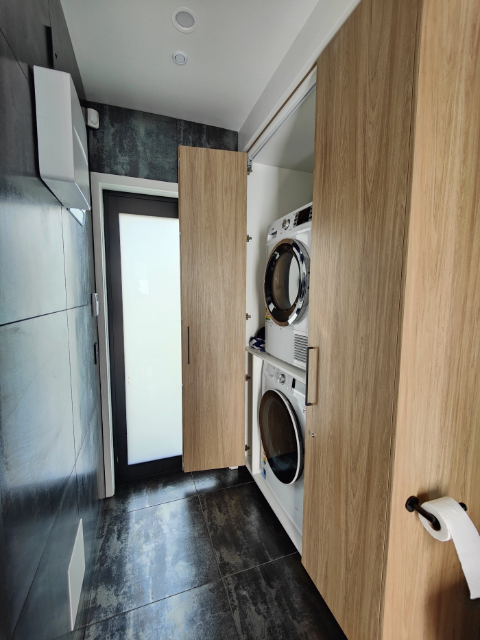 Photo of property: Tucked away in the bathroom is a laundry area for weary travellers.A washing machine, dryer and foldable clothes rack are all available for use.