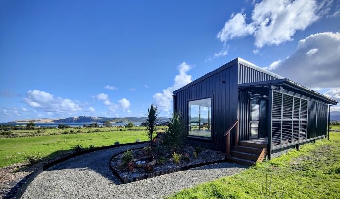 Photo of property: The pod has a beautiful outlook over the Hokianga Harbour. Adjustable louvres along the porch allow guests to control light, airflow and privacy. For EV drivers, there is also an external power socket and extension cable available for slow-charging.
